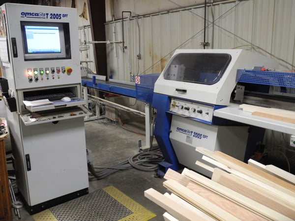Boards are fed through an Omga GT 2005 OPT cutoff saw and optimizer that cuts pieces of clean lumber.
