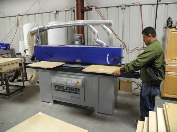 A Felder G360 edgebander is being used to edgeband cabinet parts.    